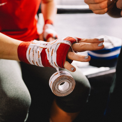 Hand wrapped in red gauze and tape in preparation for a fight